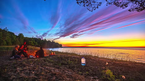 vibrant sunset with friends around a campfire by the lake