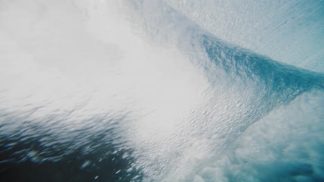 Sideview-underwater-angle-behind-tropical-blue-ocean-wave-crashing-on-reef-shimmering