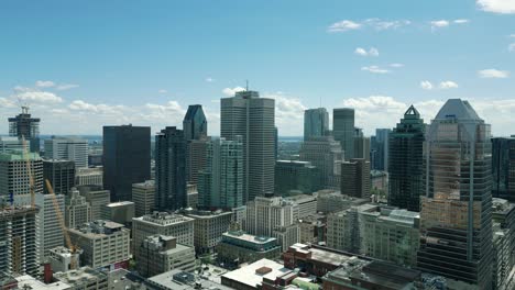 4k cinematic urban drone footage of an aerial view of buildings and skyscrapers in the middle of downtown montreal, quebec on a sunny day