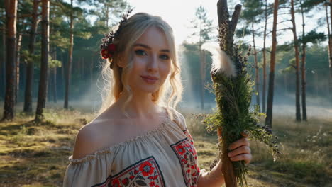 ethereal blonde woman in folk costume holding a staff in a misty forest