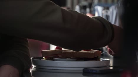 tiro de cerca mano de la gente preparar el sándwich para el desayuno y sostener el tenedor