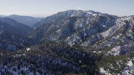 Scenic-winter-snowfall-on-mountain-chain-with-evergreen-pinewoods