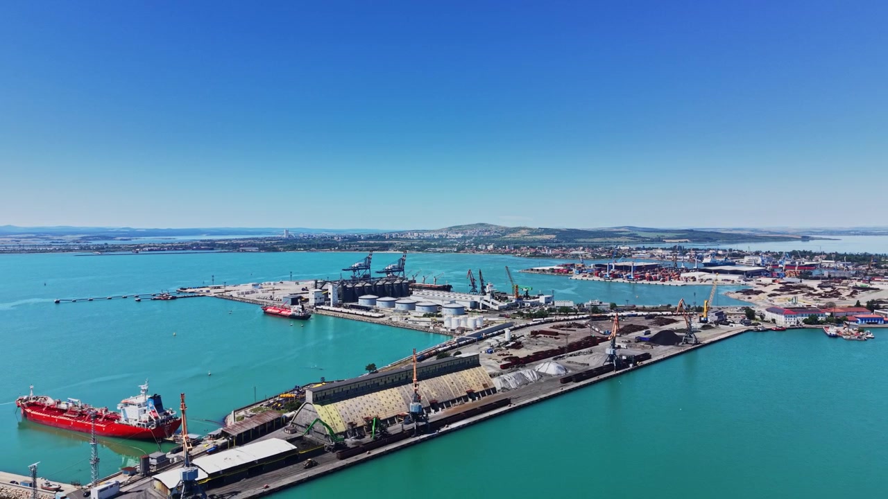 Un porto trafficato mostra gru che caricano merci sulle navi.