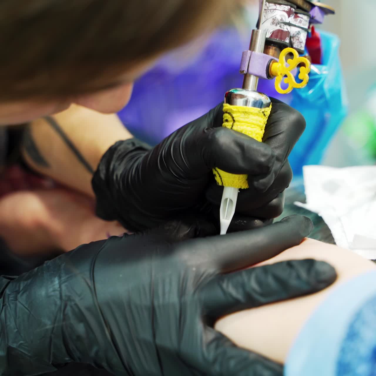 Unrecognized tattooist putting the lines on the sketch. Customer getting a tattoo on a hand. Close up