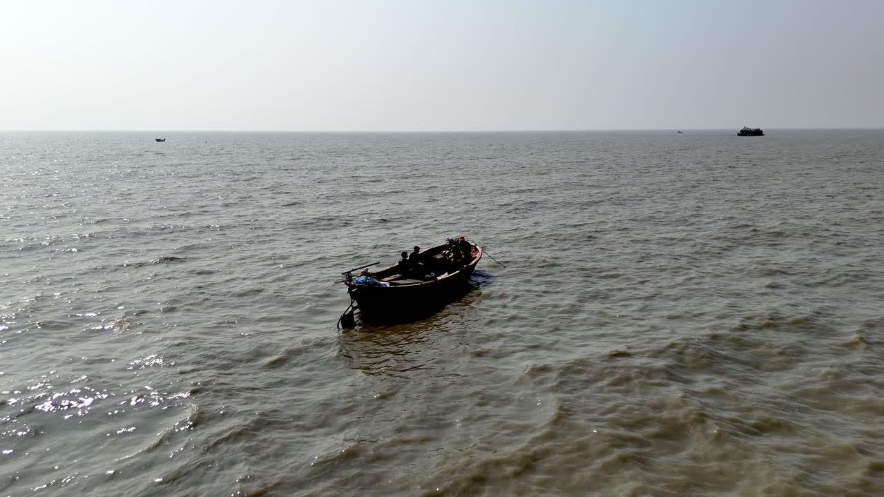 Cinematic epic aerial shot moving toward a small boat traversing a ship graveyard in Bangladesh