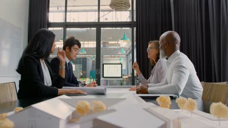 Business-executives-discussing-over-a-laptop-in-conference-room-4k