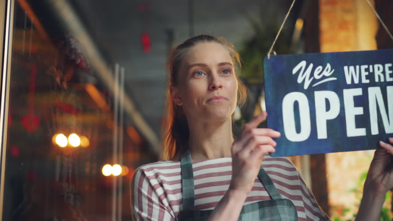 Woman Hanging Closed Sign at a Small Business