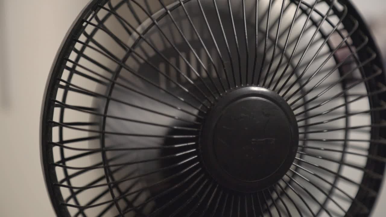 Hand's Turning On The Black Mini Fan - Close Up Shot