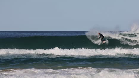 sequence of a surfer catching and riding a wave.