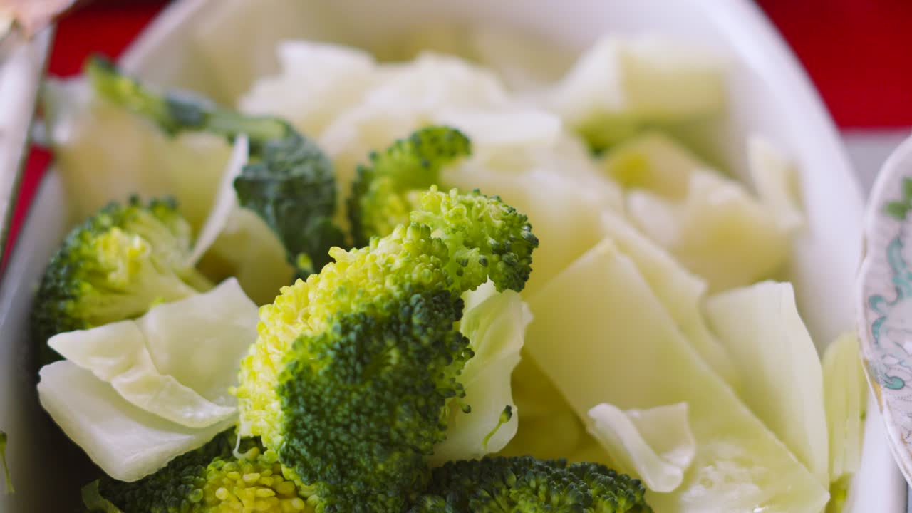 Broccoli e cavolo al vapore in una ciotola bianca. Vapore caldo che si alza da verdure sane. Prodotto biologico fresco e nutriente