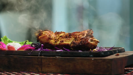 close-up roasted chicken bbq leg piece on round table with smoke in beautifull background