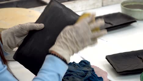 fabricación tradicional de cerámica, primer plano de las manos del alfarero dando forma a un cuenco en el hilado por arcilla