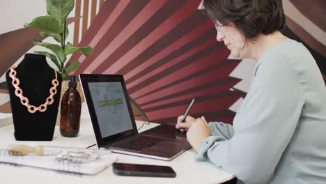 trabajadora caucásica ocupada usando una computadora portátil en una joyería en cámara lenta