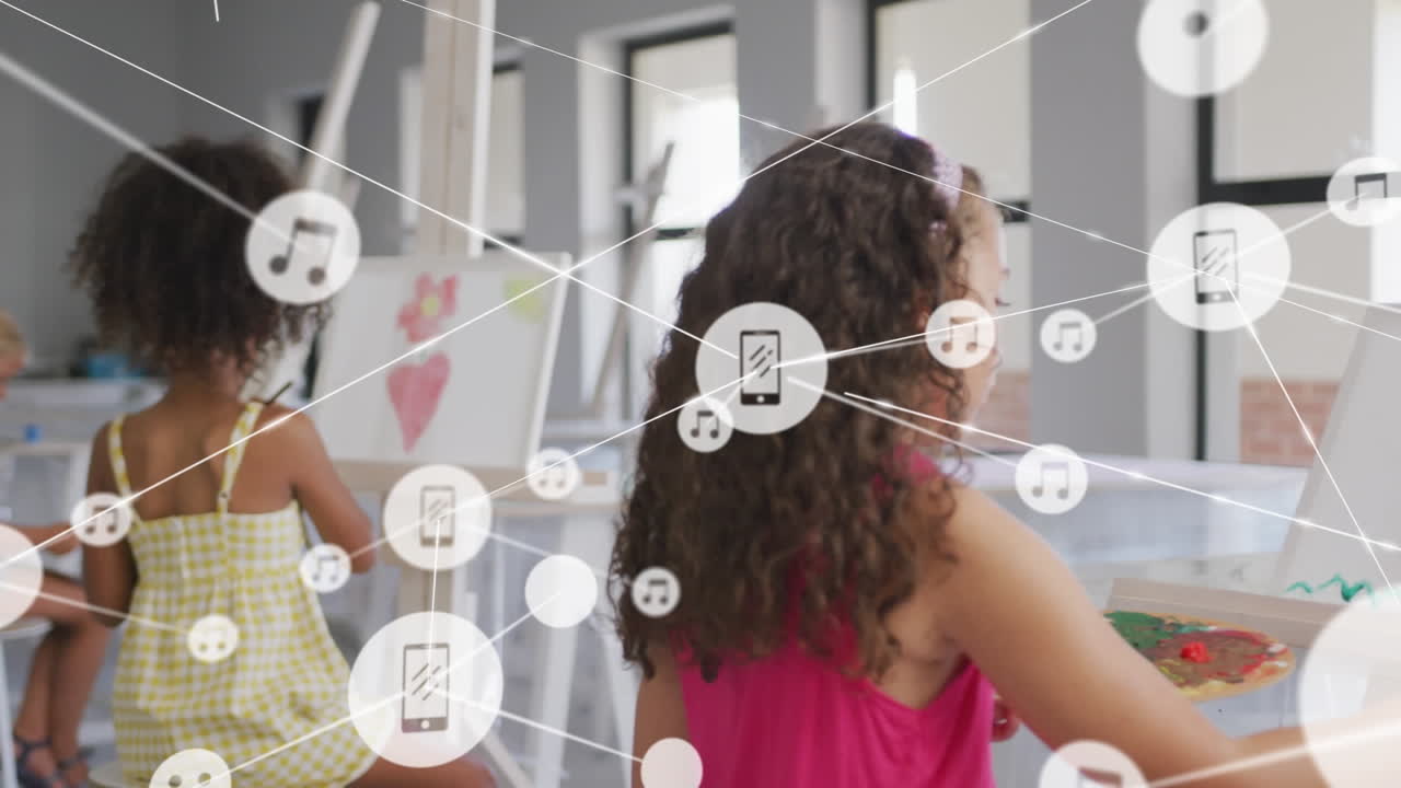 animación de una red de iconos digitales contra un grupo de niñas diversas pintando en la clase de arte en la escuela