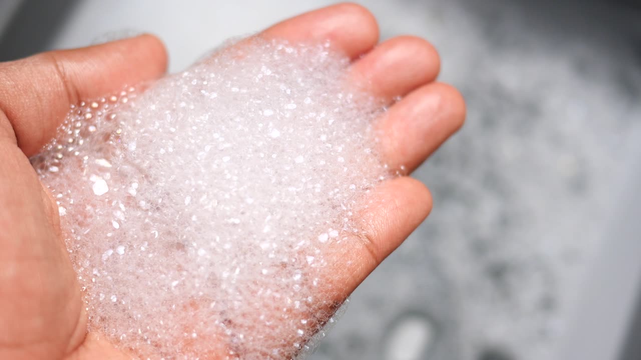 con las manos en la espuma de jabón