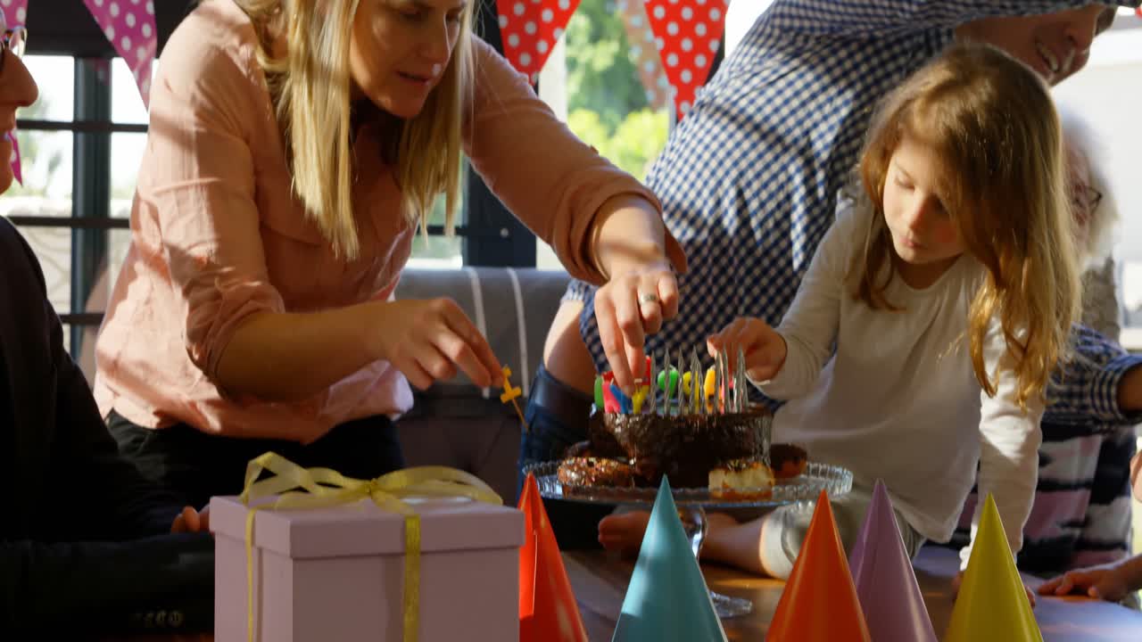 madre e hija decorando velas en el pastel de cumpleaños en la sala de estar 4k