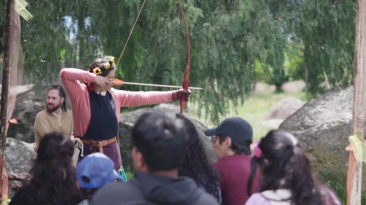 A woman teaches a group of people how to shoot an arrow during a medieval festival and Middle Ages period. Mexico