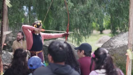 a woman teaches a group of people how to shoot an arrow during a medieval festival and middle ages period. mexico