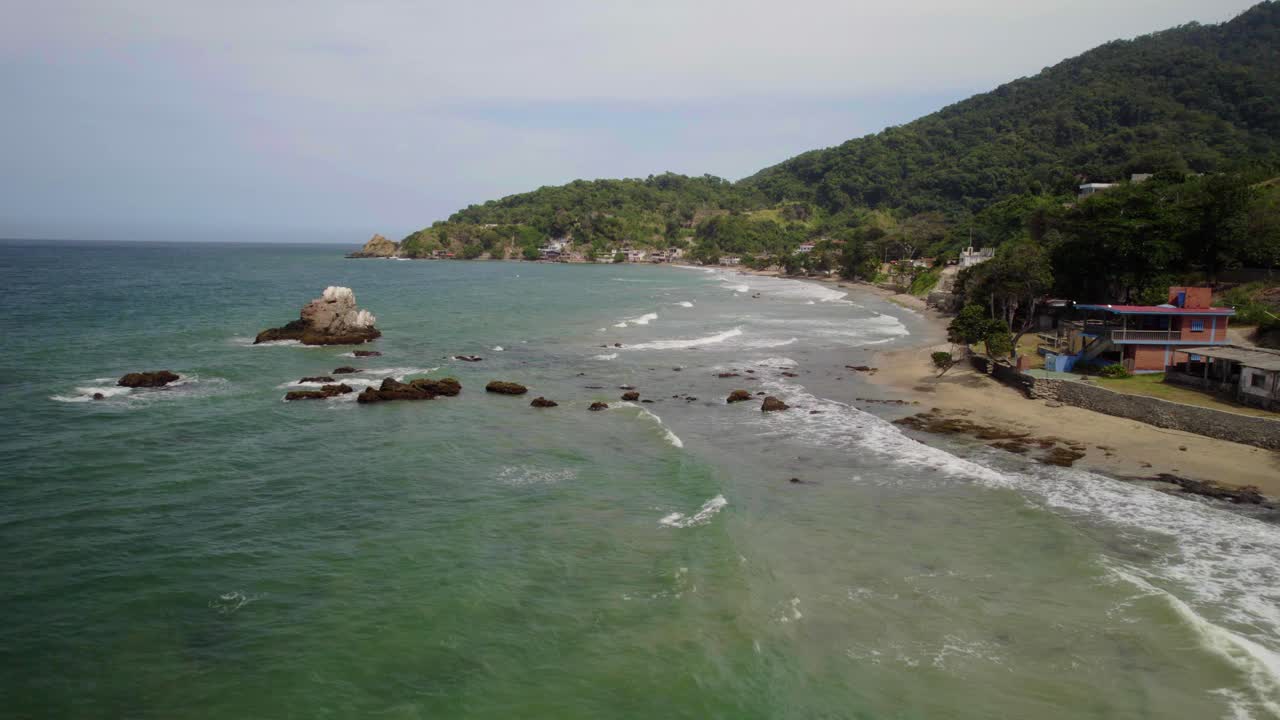A tranquil coastline at playa urama, la guaira, capturing the serene waves and rocky formations , aerial view