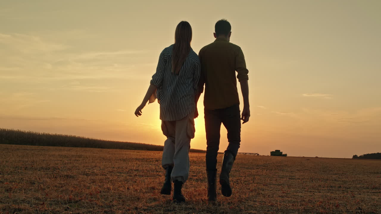 Couple Walking in a Field at Sunset