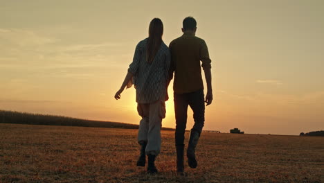 pareja caminando en un campo al atardecer