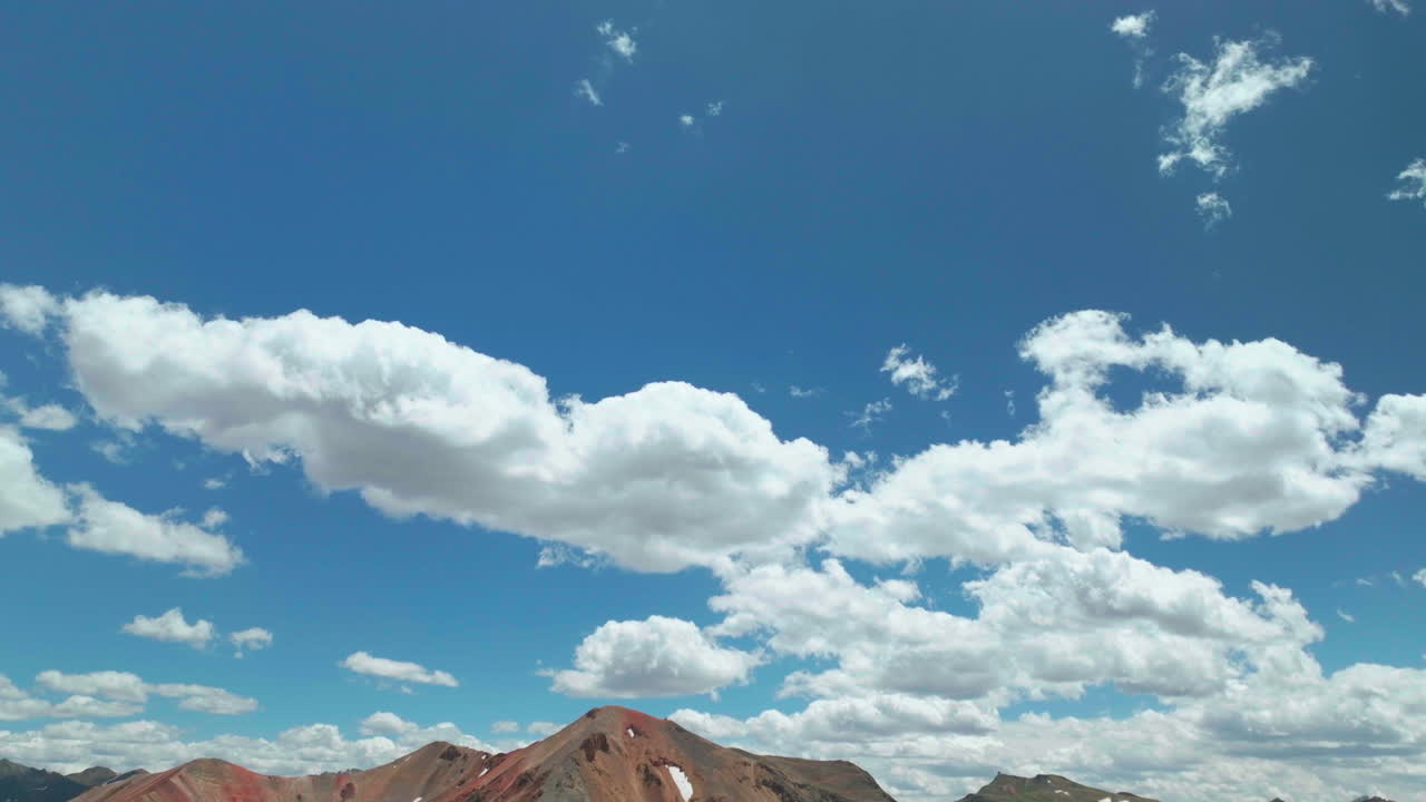 escena de apertura montañas rocosas panorámica hacia abajo y hacia arriba avión no tripulado cinematográfico verano de gran altitud montaña roja pasar ouray silverton durango sur de colorado tarde impresionante cielo azul parcialmente nublado