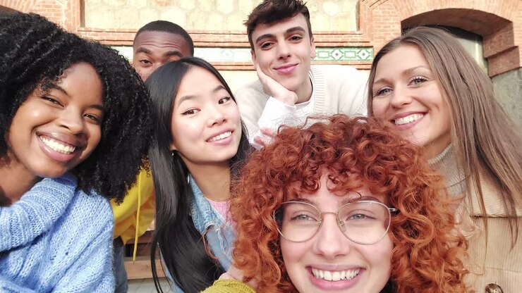 Multi-ethnic friends smiling taking a selfie in the city