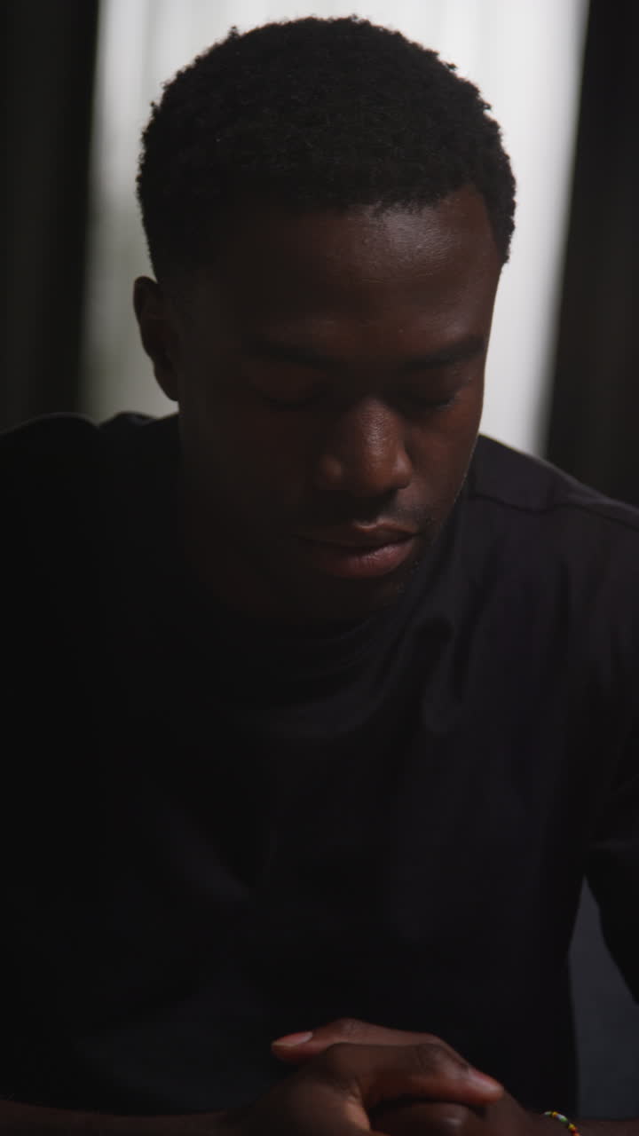 Vertical Video Of Unhappy And Depressed Young Man Sitting On Sofa At Home Looking Anxious And Worried Closing Eyes And Shaking Head
