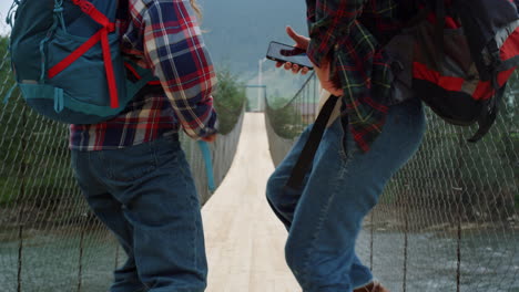parejas de piernas bailando juntas en el puente del río naturaleza. turistas moviendo el cuerpo afuera.
