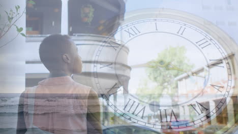 animación de reloj en movimiento y paisaje marítimo sobre mujer afroamericana
