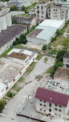 flying over abandoned industrial factory buildings in very dilapidated condition.. vertical video