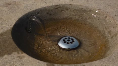 Slow-motion-close-up-of-a-drinking-fountain-faucet