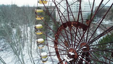 noria oxidada y ciudad de pripyat de invierno en la zona de exclusión de chernobyl