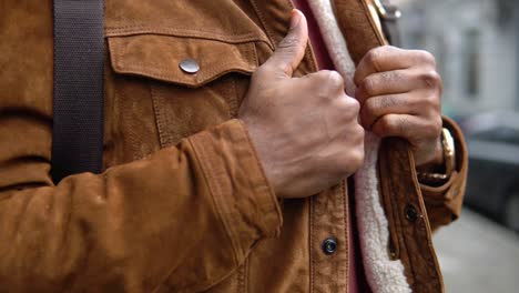 black man with shoulder backpack stands outdoor near the office center