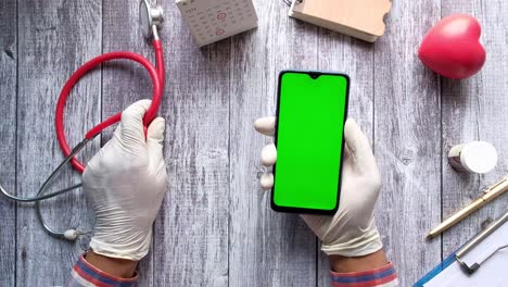 médico que utiliza un teléfono inteligente con un estetoscopio