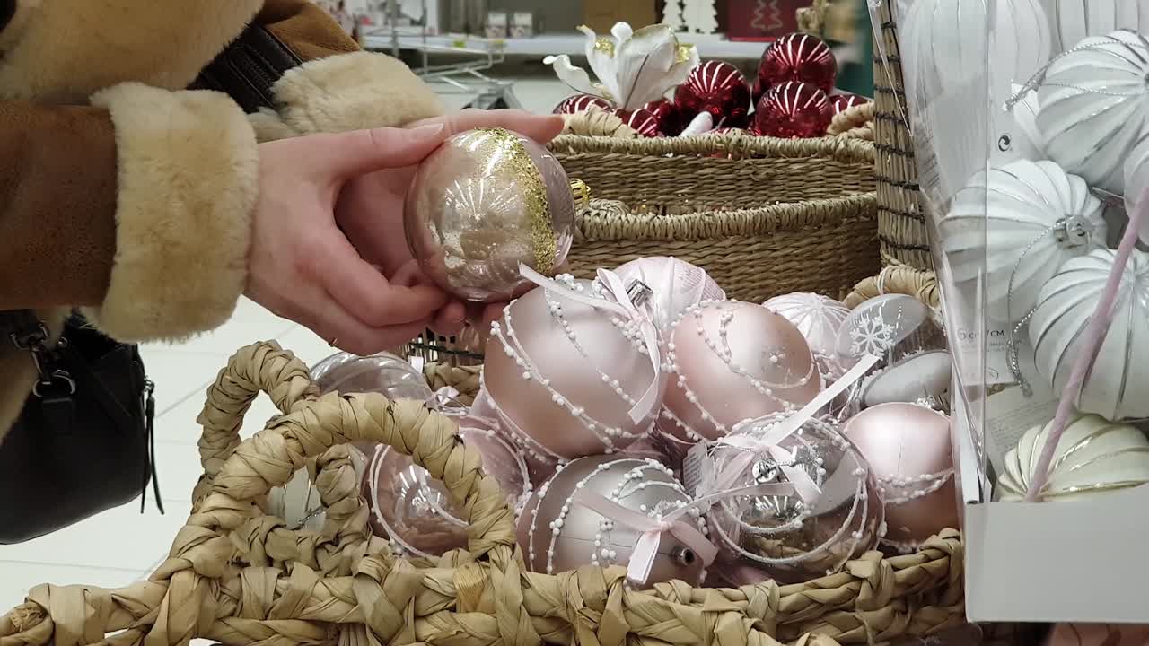 Selezione e acquisto in negozio di decorazioni natalizie per l'albero di Natale