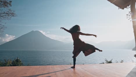 Silhouette-of-attractive-woman-dancing-on-sunny-day-with-view-to-volcano