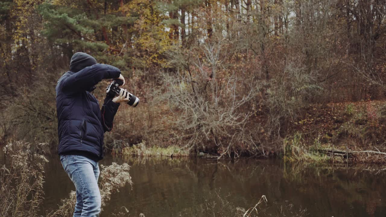 Man standing on shore. Aerial view of man standing on lake shore and taking photo of nature
