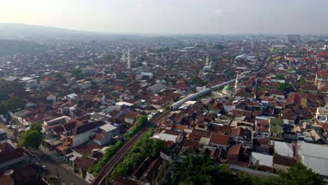 Zona-De-Tugurios-Densamente-Poblada-En-Indonesia,-Con-Vías-De-Ferrocarril-Atravesando