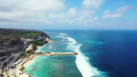 beautiful balinese coast with the cliffs and foamy waves washing on the fringing coral reef