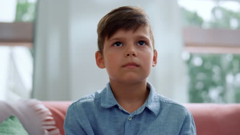 Boy-playing-computer-game-with-joystick-in-living-room.-Gamer-using-gamepad