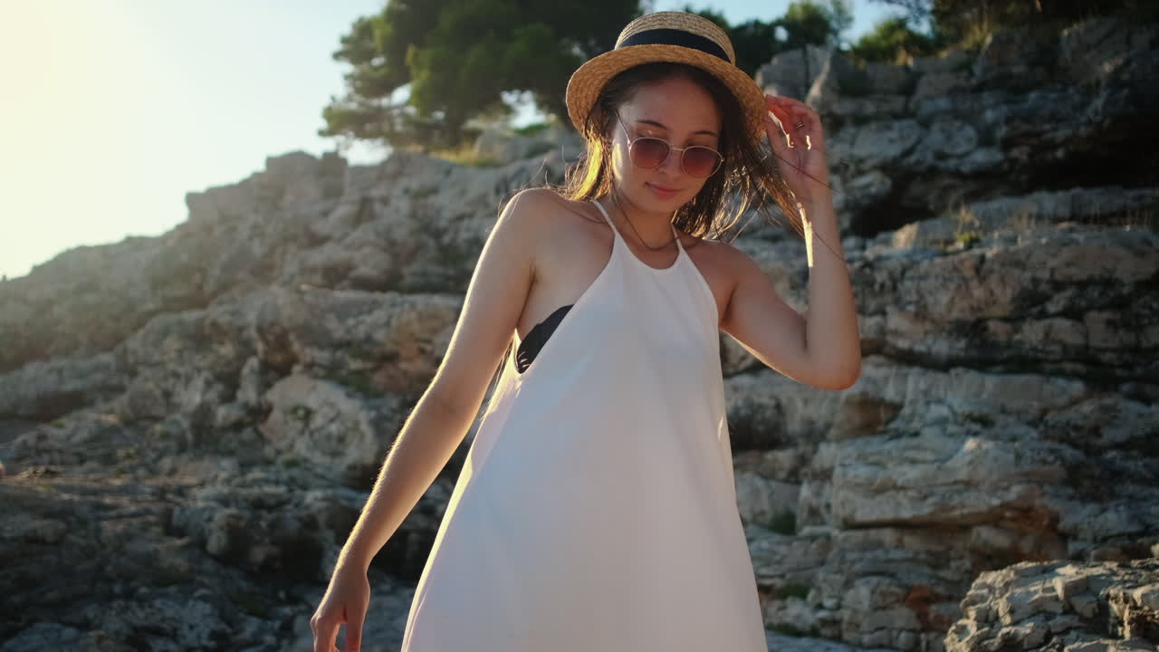 바위 해변 에서 해가 지는 것 을 즐기는 여자