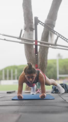 woman performing plank exercise outdoors