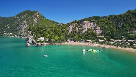 Aerial view of vibrant beach with clear blue sea and lush green hills