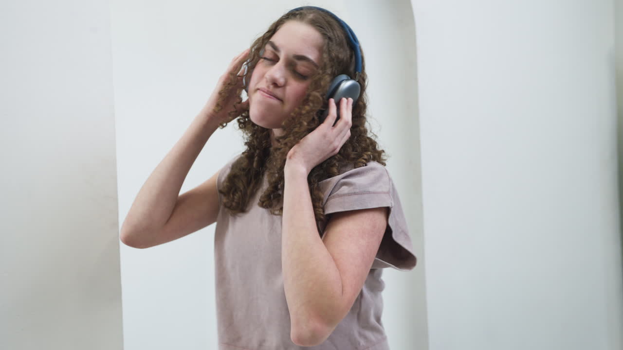 Teenage girl dancing passionately with eyes closed while listening to music