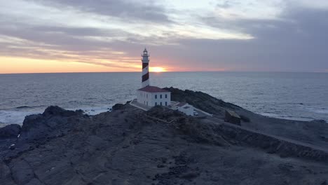 toma cinematográfica de un faro a lo largo de la costa de menorca al atardecer