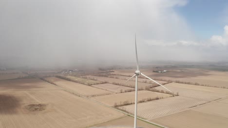 vista aérea de una sola turbina eólica en el campo de los agricultores