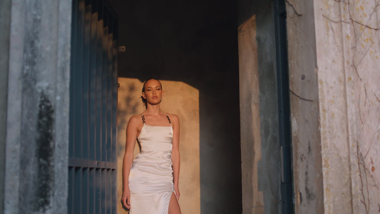 중세 성의 입구에 서서 빛을 즐기는 평온한 소녀. 감각적인 여인