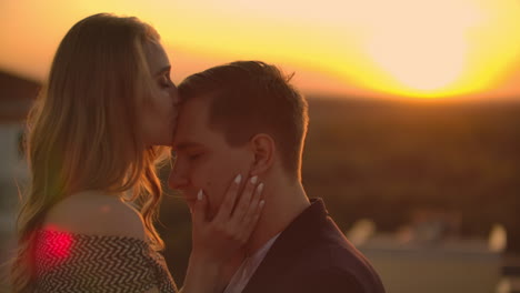 encantadora dulce felicidades pareja sentarse en el techo con increíble vista de la puesta de sol en la ciudad urbana ciudad. se aman abrazos muy ternura sol va entre el cabello