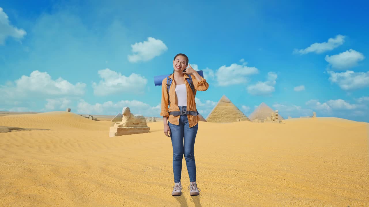 Full Body Of Asian Female Hiker With Mountaineering Backpack Smiling And Showing Call Me Gesture While Traveling In Pyramid Of Giza